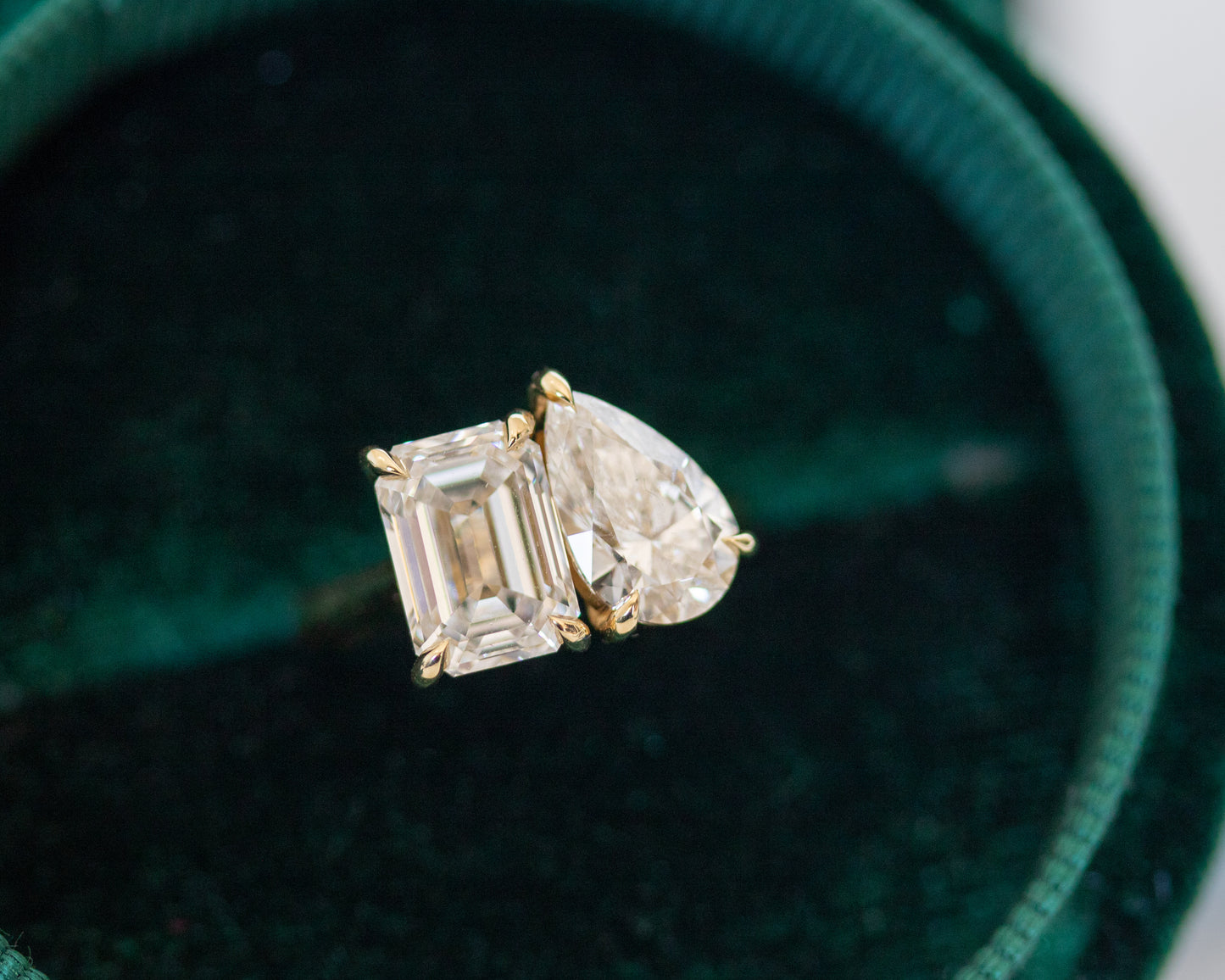 Emerald and pear diamond Toi et Moi ring in 14K yellow gold in a green velvet box, close-up