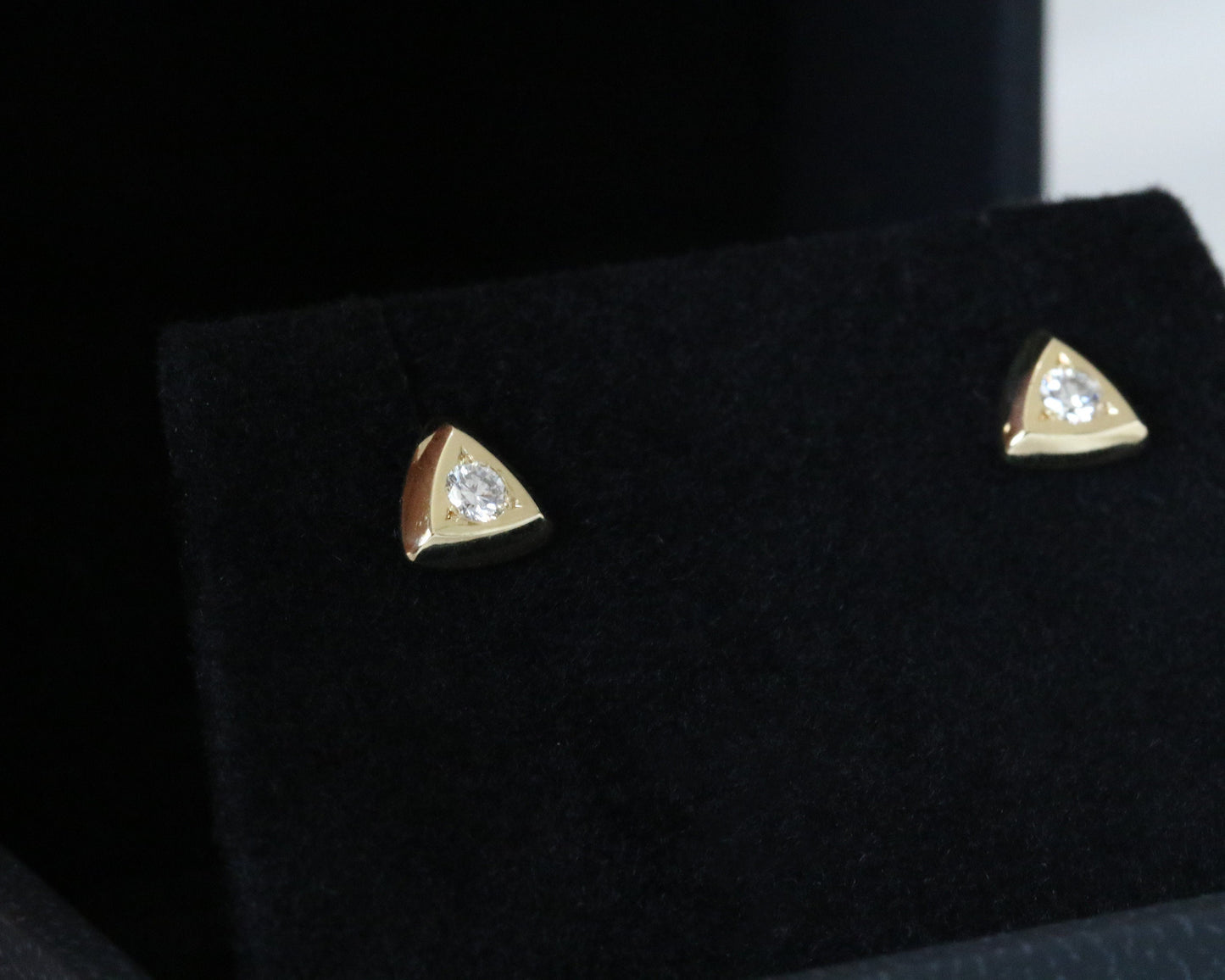 Round diamond triangular gold studs on black display