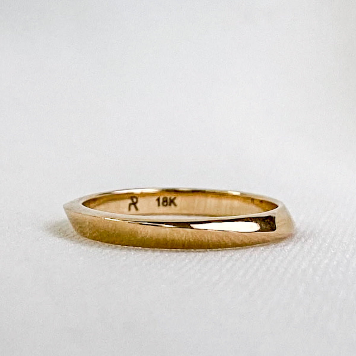 Twisted yellow gold wedding band, 2.7 mm, on a white background