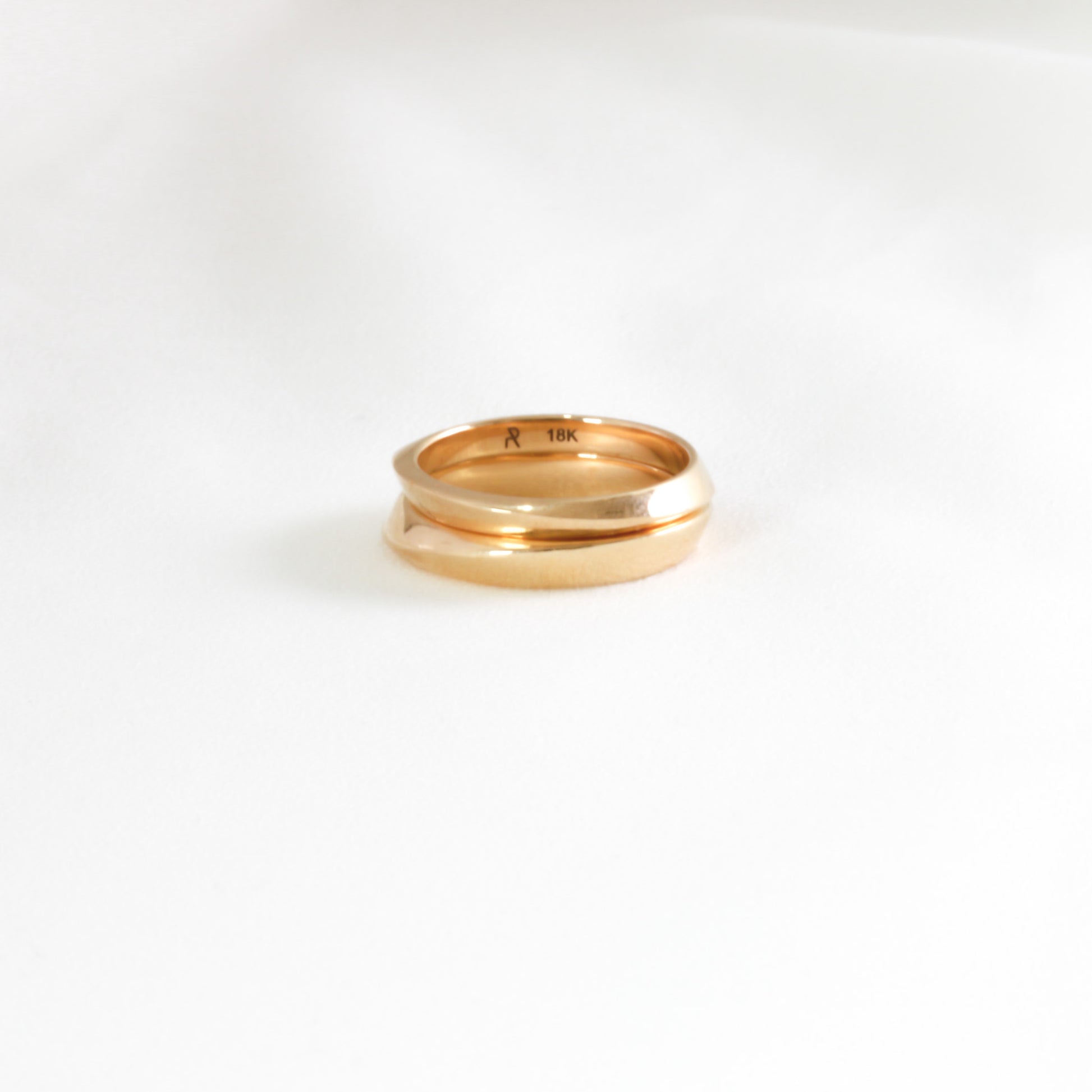 two gold rings stacked on white background