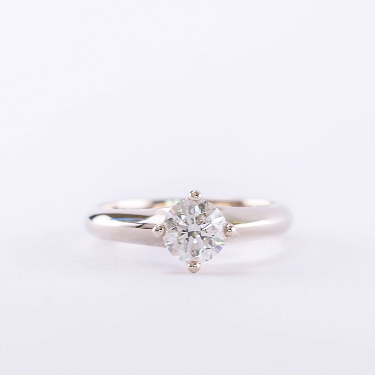 A 14K white gold solitaire ring with a round natural diamond centerpiece.