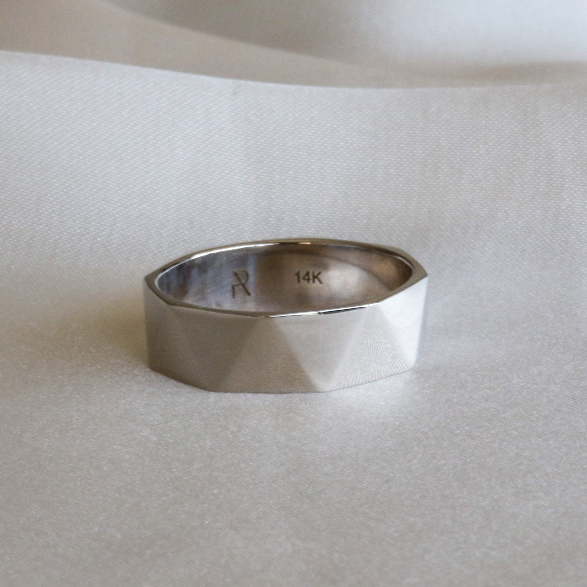 triangle faceted white gold ring on white cloth