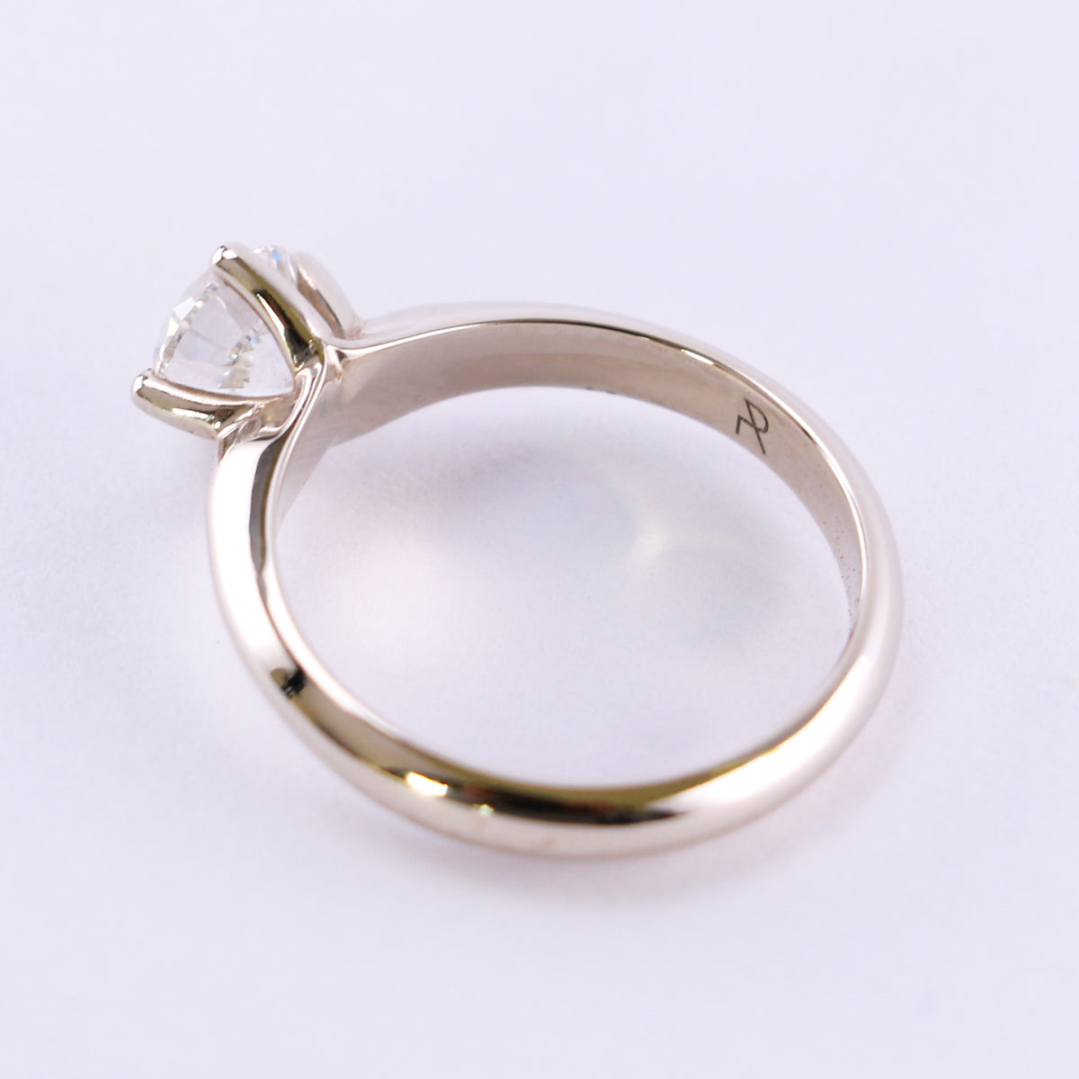 White gold solitaire ring with a round diamond, tilted top view