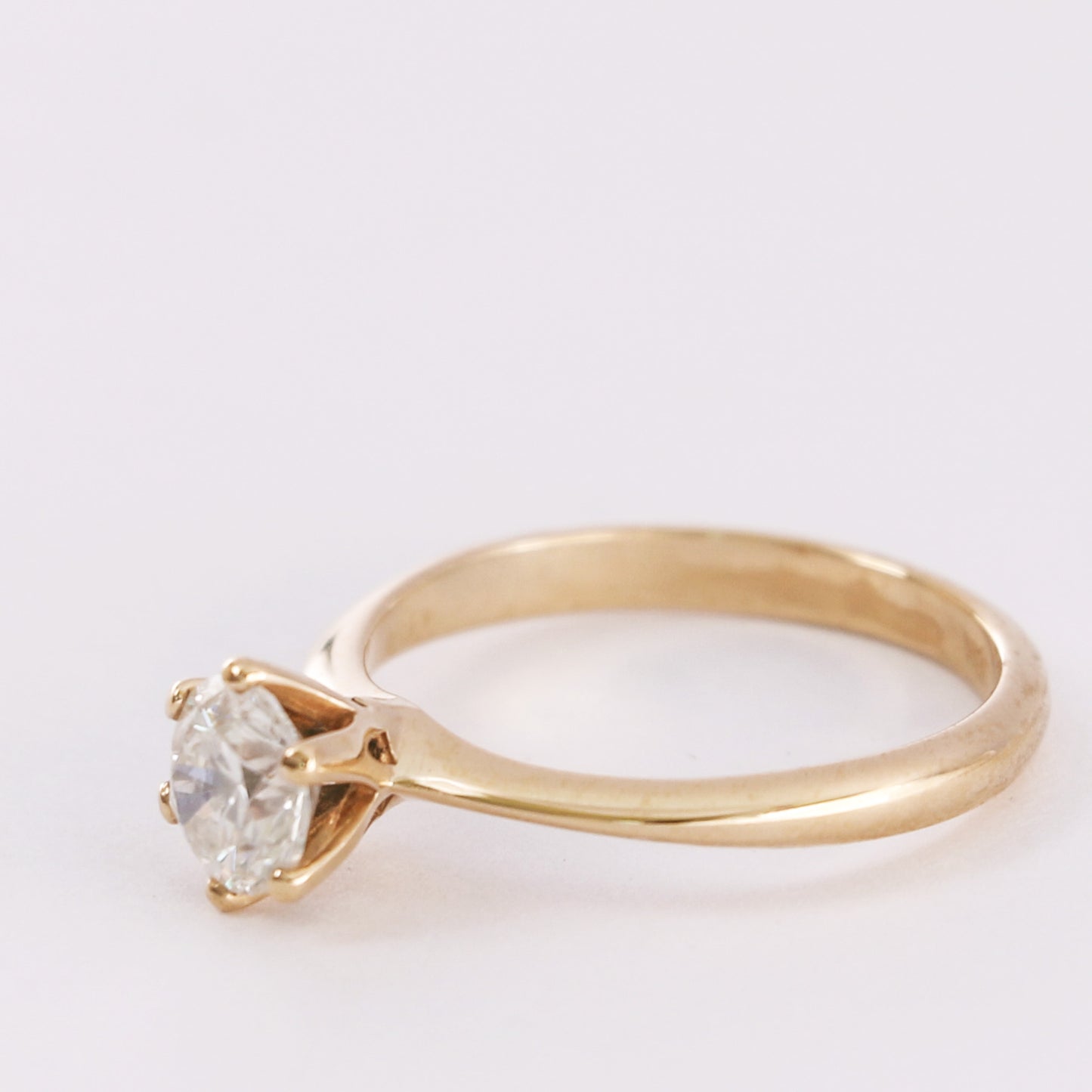 yellow gold diamond solitaire ring facing off side showing rings structure