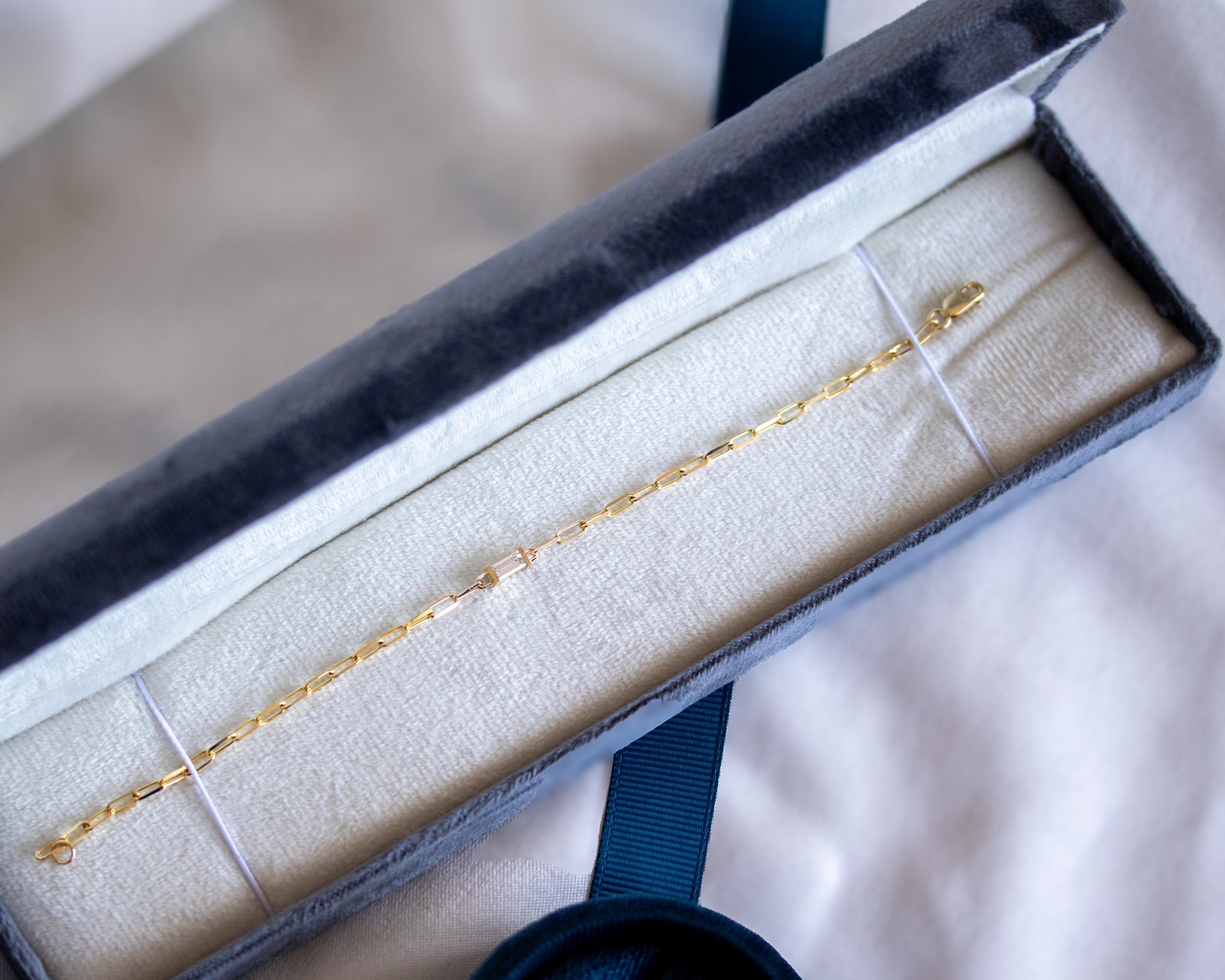 Gold bracelet in an open jewelry box on a soft surface