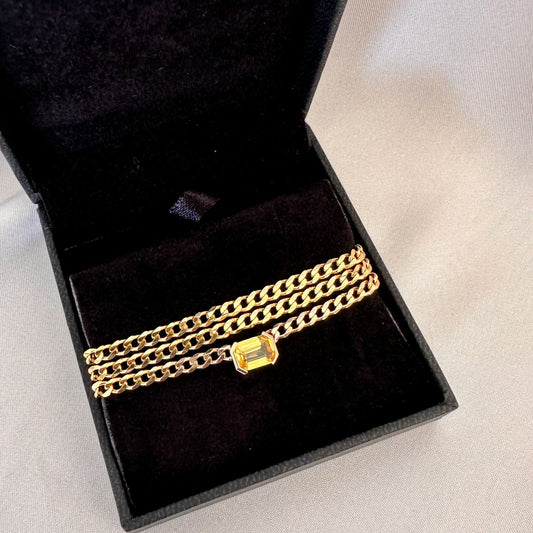 Fine 14K gold curb chain choker with an emerald cut yellow sapphire in a black jewelry box